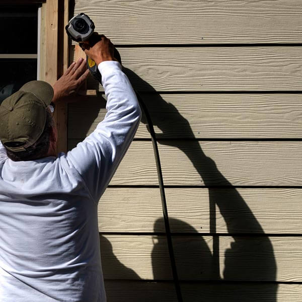 man assembling siding on home exterior
